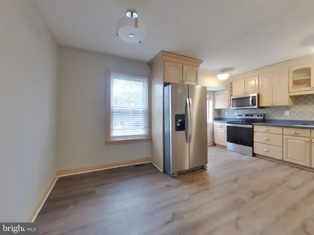 a kitchen with stainless steel appliances a refrigerator and wooden cabinets