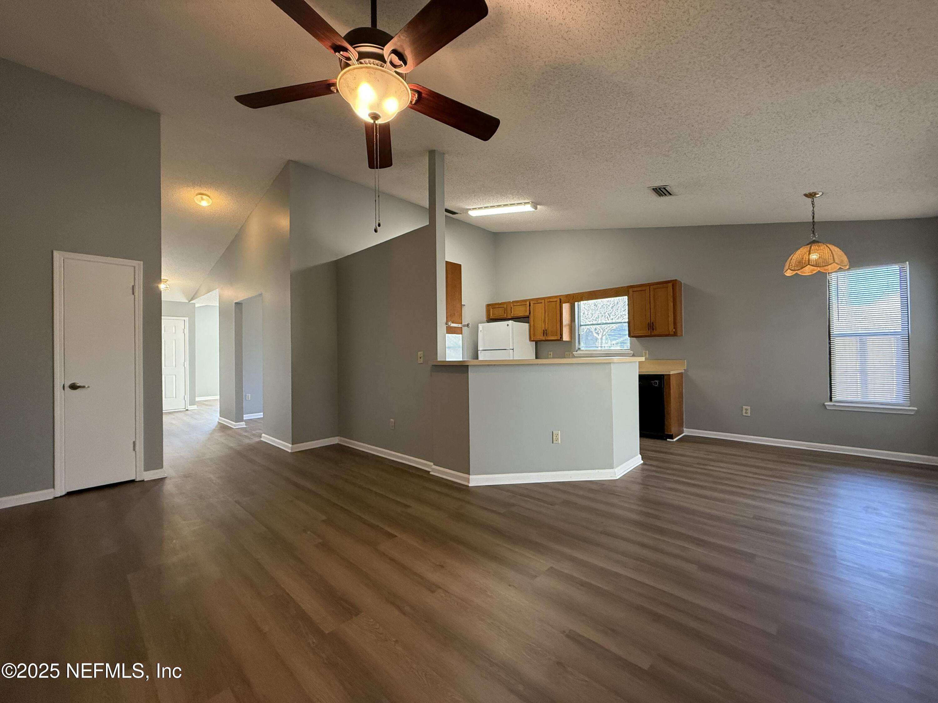 325 Quebec Lane Jacksonville, FL 32225 - Photo 6 of 24 a view of a kitchen with a fridge wooden floor and a ceiling fan