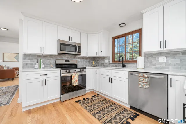 a kitchen with stainless steel appliances granite countertop a stove a sink and a microwave