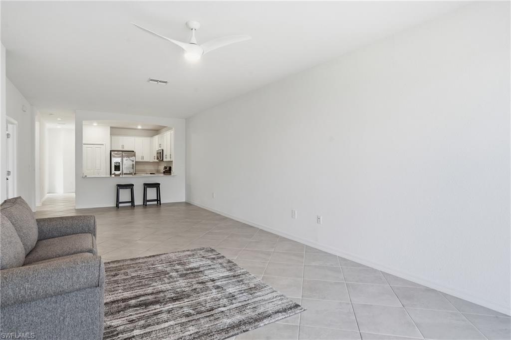 2215 Dragonfruit Way Naples, FL 34120 - Photo 7 of 38 a living room with furniture and kitchen view