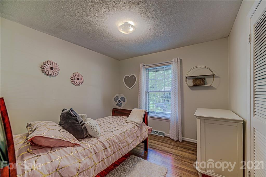 11328 Torino Road Matthews, NC 28105 - Photo 18 of 23 a bedroom with a bed and a lamp with wooden floor