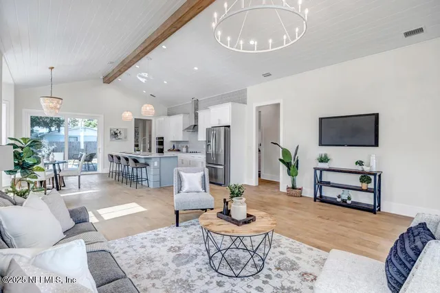 a living room with furniture a dining table and a flat screen tv