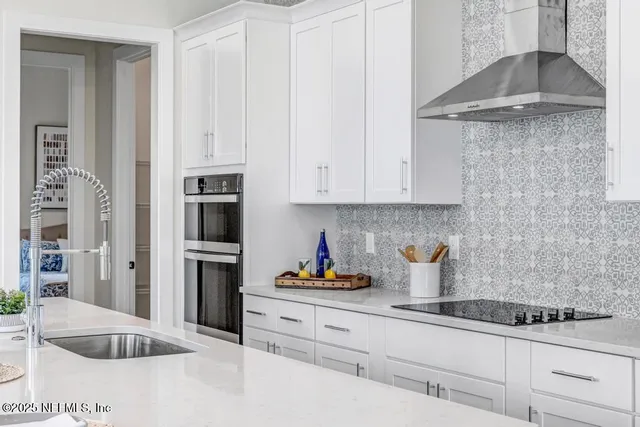 a kitchen with stainless steel appliances white cabinets and a refrigerator