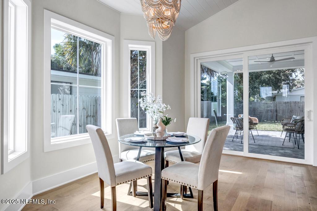 552 Seagate Avenue Neptune Beach, FL 32266 - Photo 14 of 29 a dining room with furniture a chandelier and wooden floor
