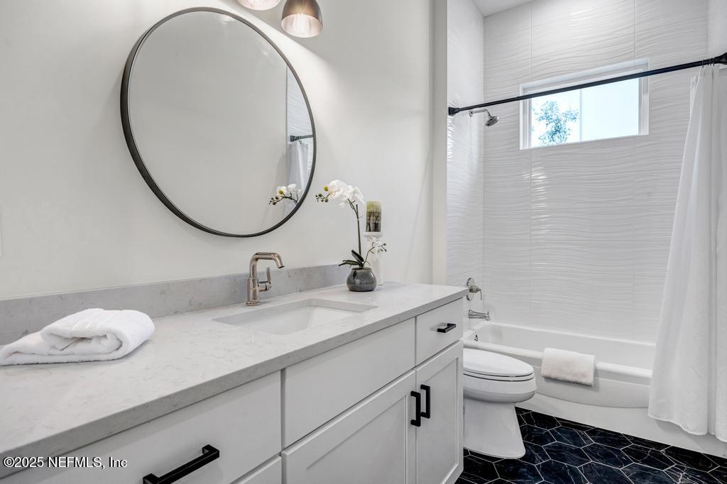 552 Seagate Avenue Neptune Beach, FL 32266 - Photo 21 of 29 a bathroom with a granite countertop toilet sink and mirror