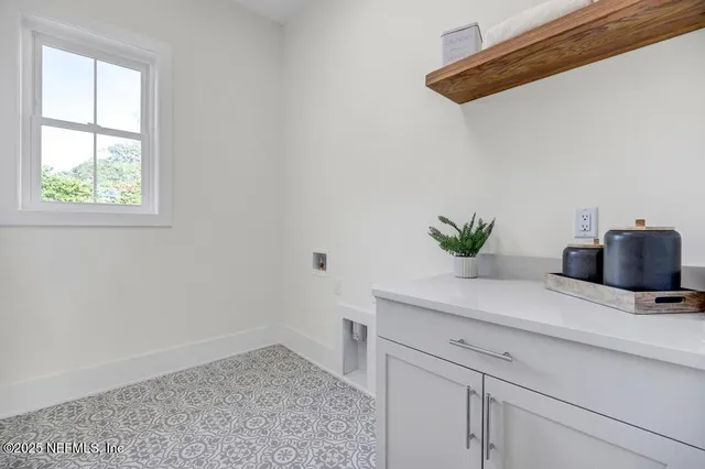 a view of kitchen with a potted plant on the counter and cabinets