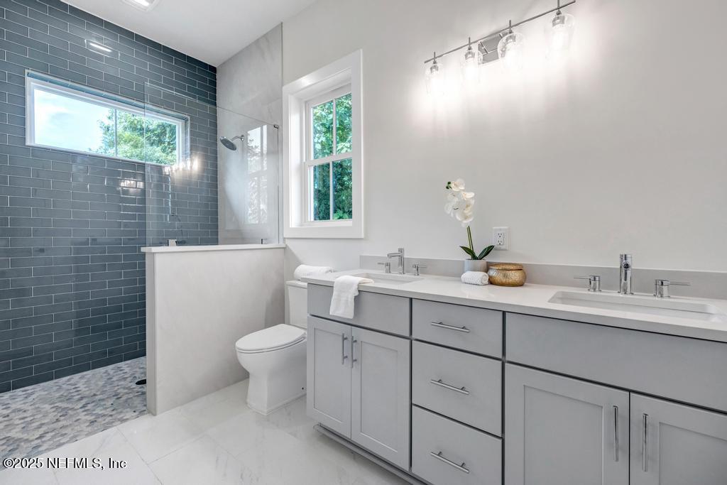 552 Seagate Avenue Neptune Beach, FL 32266 - Photo 6 of 29 a bathroom with a toilet sink and mirror