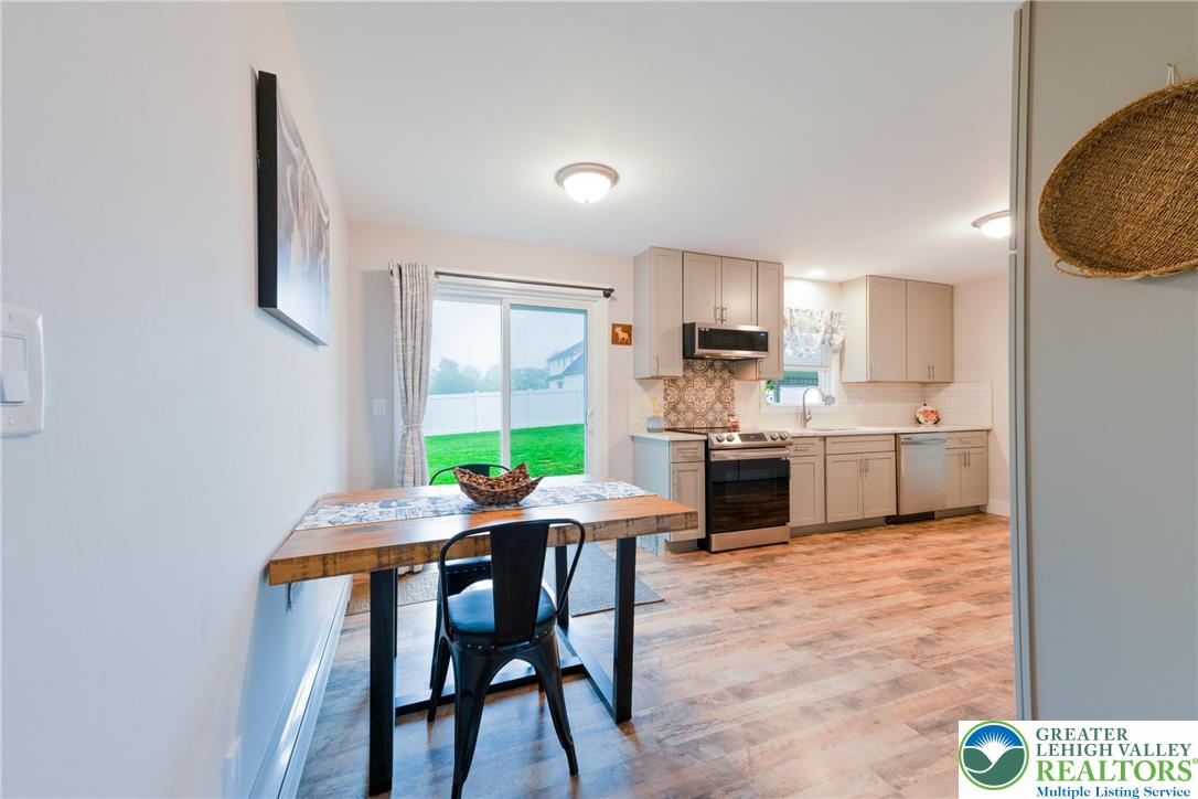 677 English Road Bath, PA 18014 - Photo 7 of 26 a kitchen with a table chairs refrigerator and microwave