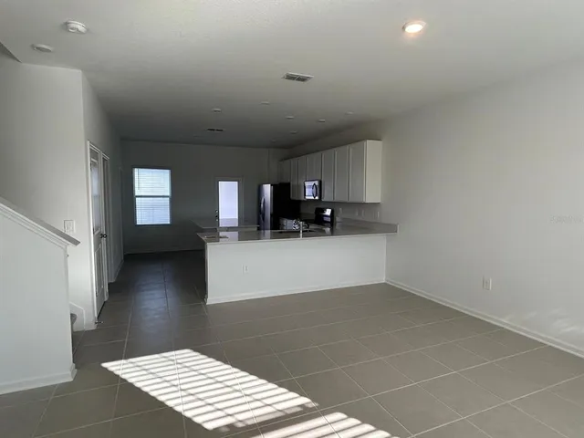 a view of kitchen and hall with wooden floor and a cabinet