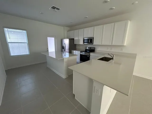 a kitchen with a sink a stove and cabinets