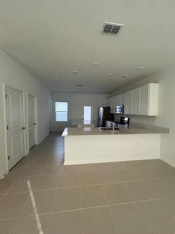 a view of kitchen with stainless steel appliances granite countertop a sink and cabinets
