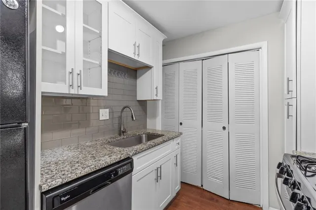 a kitchen with a granite countertop sink and cabinets
