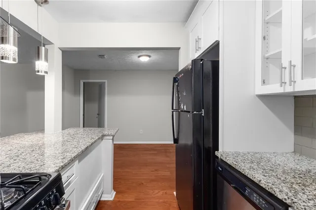 a kitchen with granite countertop a refrigerator and a sink