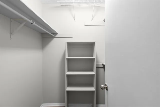 a view of walk in closet with empty racks