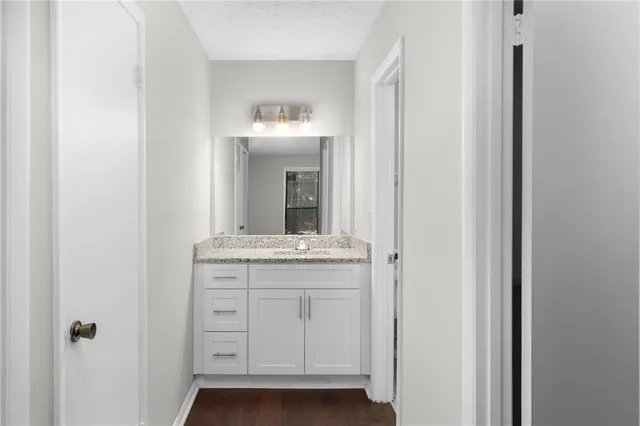 a bathroom with a granite countertop sink and a mirror