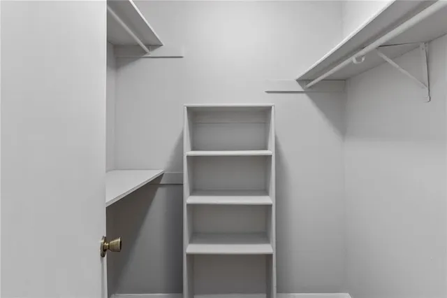 a view of walk in closet with empty racks