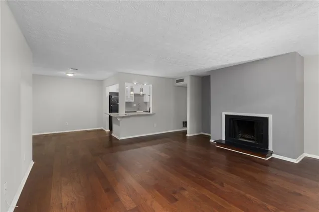 a view of wooden floor fire place and windows in a room