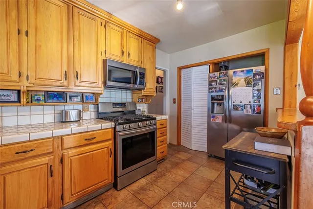 a kitchen with stainless steel appliances granite countertop a stove a refrigerator and cabinets