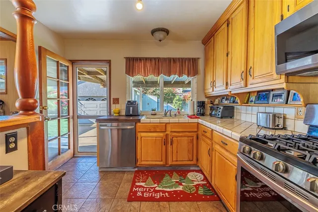 a kitchen with stainless steel appliances granite countertop a stove a sink dishwasher and cabinets with wooden floor