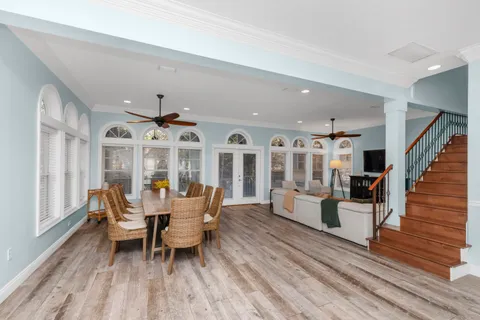 a dining room with wooden floor and a large window