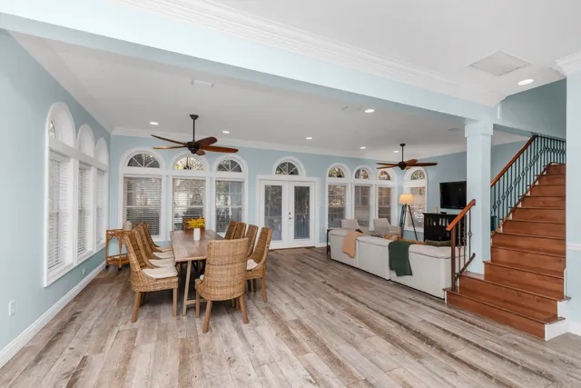 a dining room with wooden floor and a large window