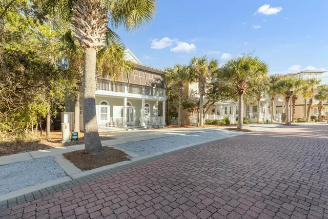 a front view of a house with a yard and potted plants