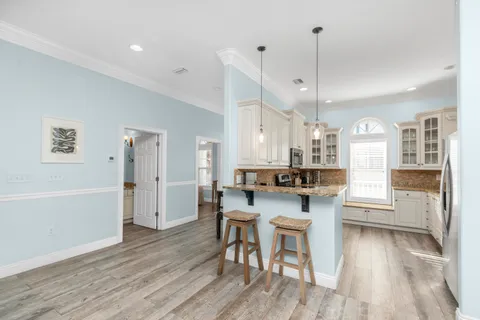 a kitchen with stainless steel appliances granite countertop a stove and white cabinets