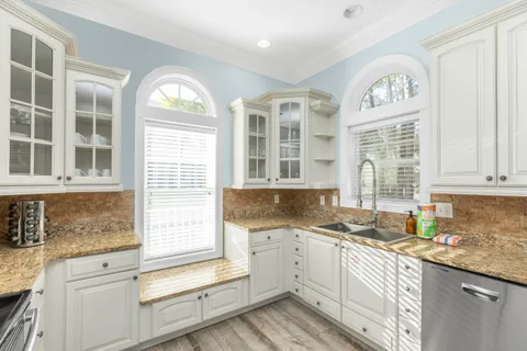 a living room with furniture a large window and a chandelier