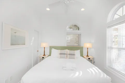 a bedroom with a bed and a flat tv screen on the dresser