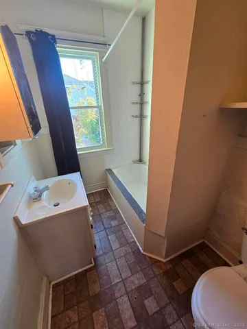a bathroom with sink toilet and window