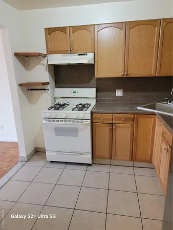 a kitchen with a stove top oven cabinets and utility