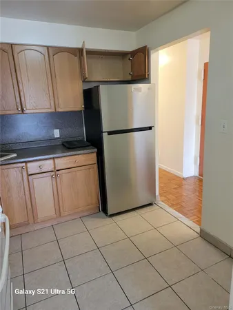 a kitchen with white cabinets and refrigerator