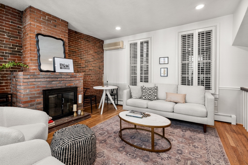 22 Shawmut Street Boston, MA 02116 - Photo 5 of 26 a living room with furniture a rug a window and a fireplace