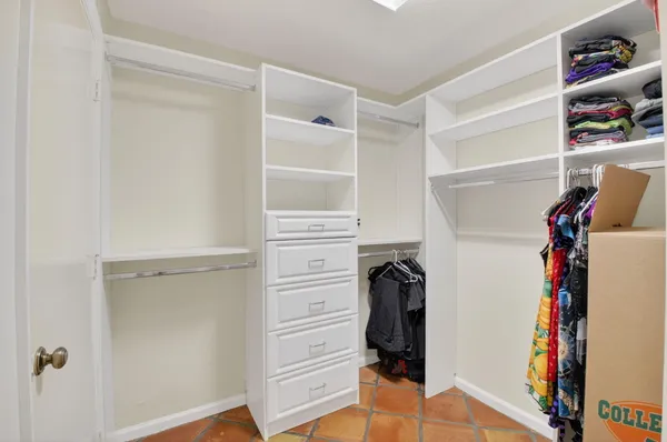 a view of walk in closet with clothes and shoes