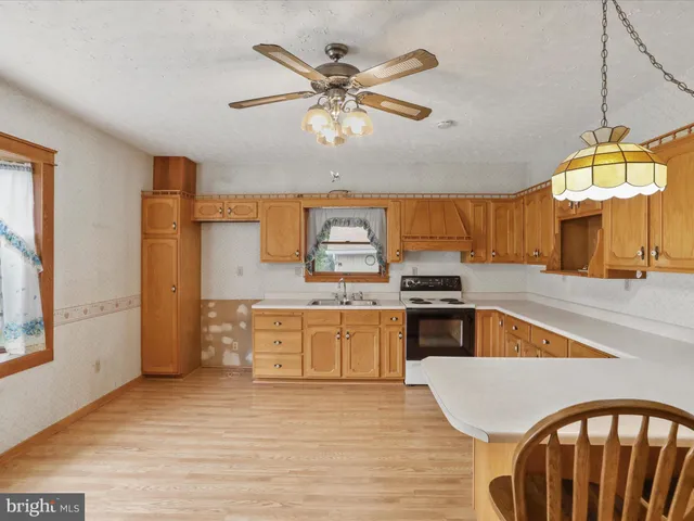 a kitchen with stainless steel appliances granite countertop a stove cabinets and wooden floor