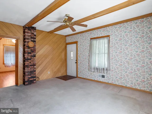 a view of a livingroom with wooden floor and a ceiling fan