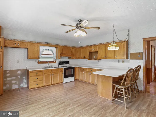 a kitchen with stainless steel appliances granite countertop wooden floors and white cabinets