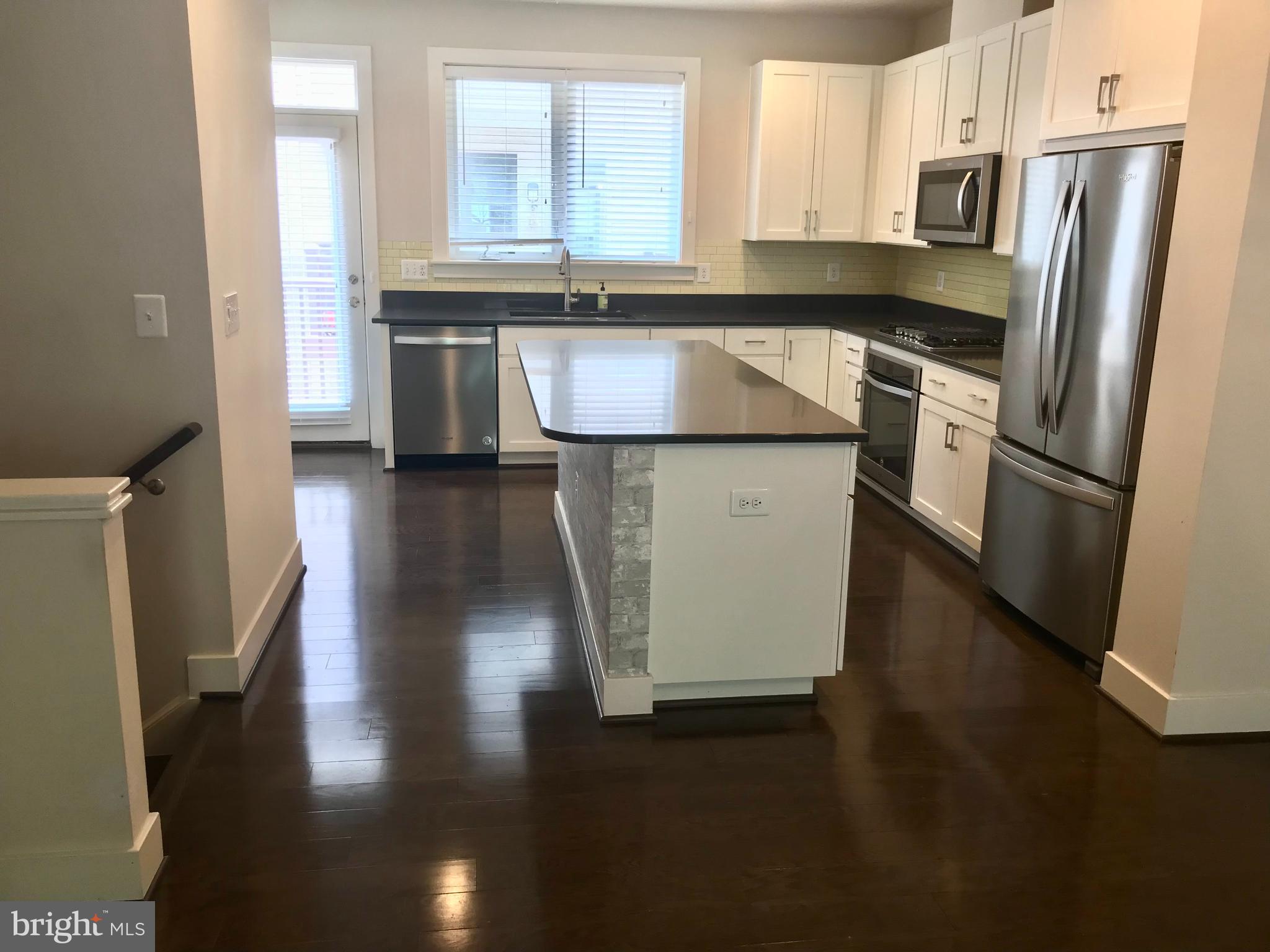 16316 Decker Place Rockville, MD 20855 - Photo 13 of 27 a kitchen with stainless steel appliances granite countertop a refrigerator a stove a sink and a microwave
