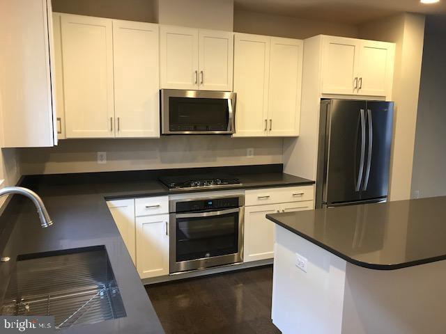 16316 Decker Place Rockville, MD 20855 - Photo 15 of 27 a kitchen with stainless steel appliances granite countertop a sink a stove and refrigerator