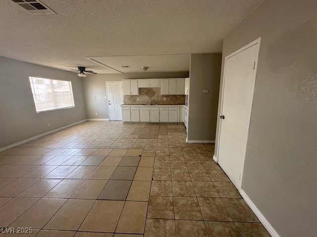 3106 Cummings Street North Las Vegas, NV 89030 - Photo 2 of 12 Unfurnished living room featuring a textured ceiling, light tile patterned floors, and ceiling fan