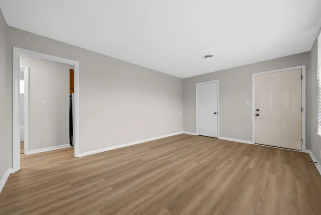 a view of an empty room with wooden floor