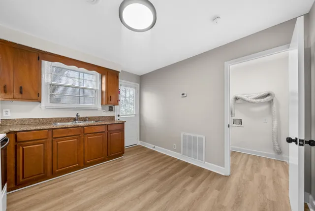 a large kitchen with granite countertop a sink and a stove top oven