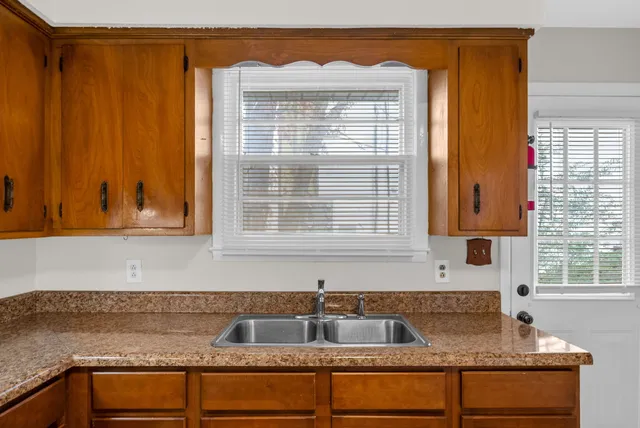 a kitchen with granite countertop a sink and a window