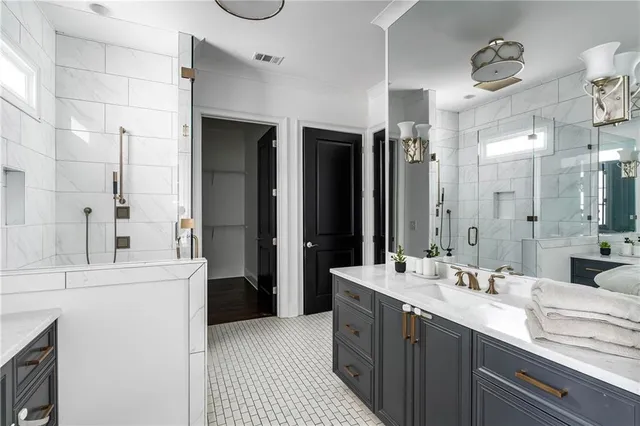 a bathroom with a double vanity sink a toilet a mirror and shower