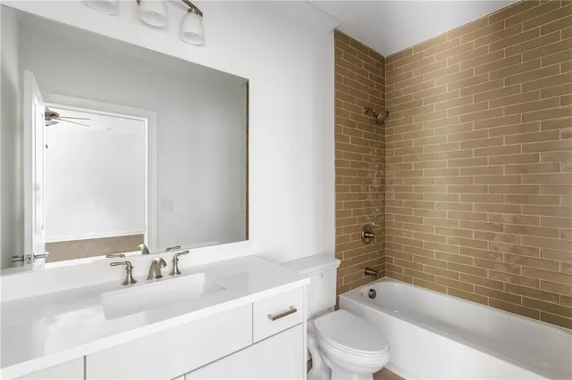 a bathroom with a bathtub shower sink vanity and toilet