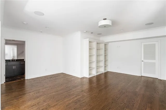 a view of empty room with wooden floor and ceiling fan