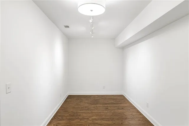 a view of a room with wooden floor and white walls