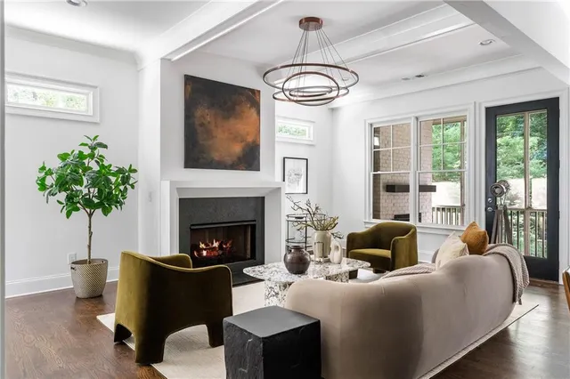 a living room with furniture potted plant a fireplace and a window