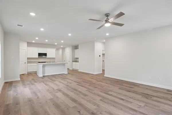 a view of kitchen with refrigerator and white cabinets