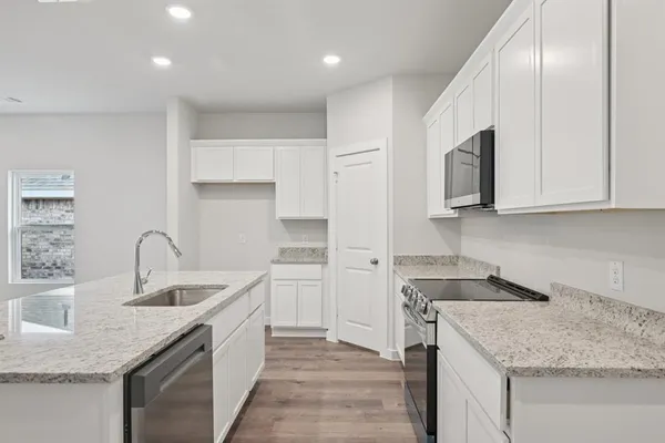 a kitchen with stainless steel appliances granite countertop a sink stove and cabinets